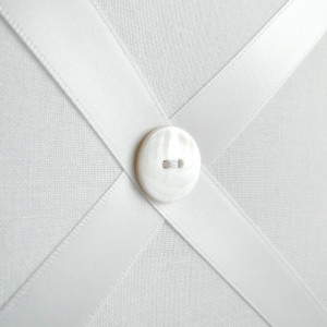 Close up of white ribbon memo board showing white button detail
